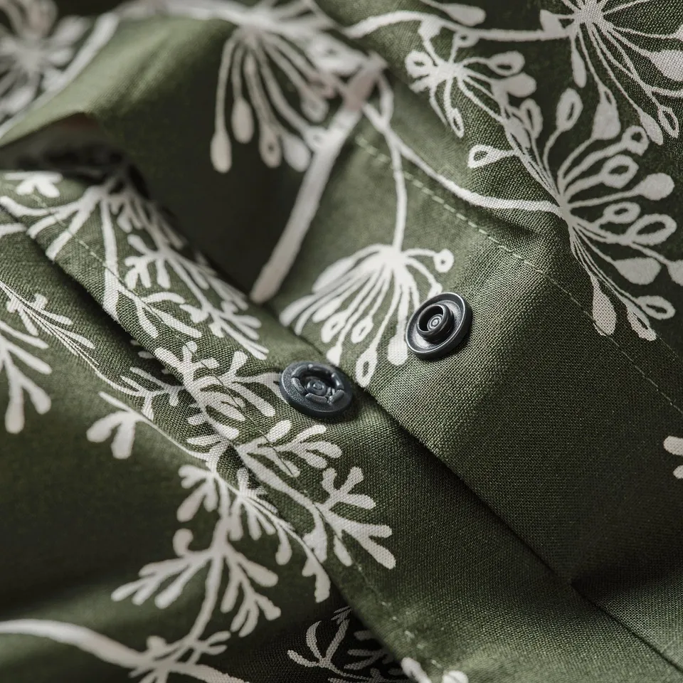 Dark green duvet cover with white floral print, featuring black buttons for closure.