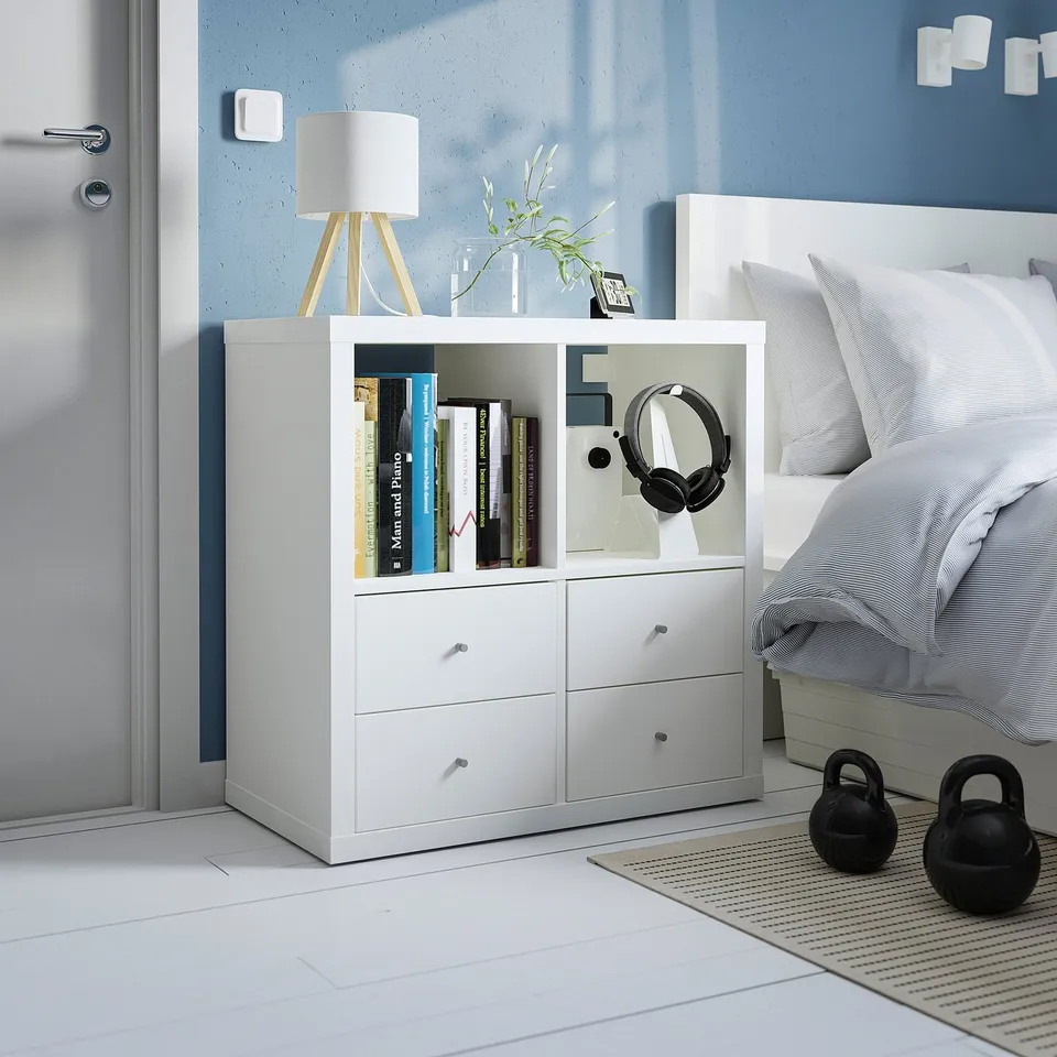 KALLAX shelf with drawers, lamp, flowers, books, headphones, kettlebells.