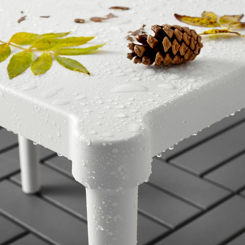 White childrens table with water droplets; small pinecone and leaves. Ideal for outdoor crafts and play.
