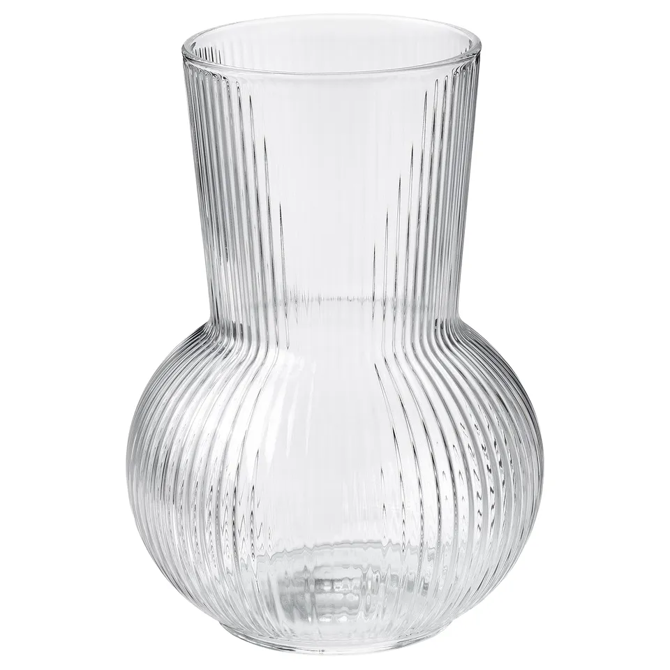 A clear glass PÅDRAG vase with a rounded, ribbed design for a textured look. Its elegant and versatile for holding flowers or decoration.