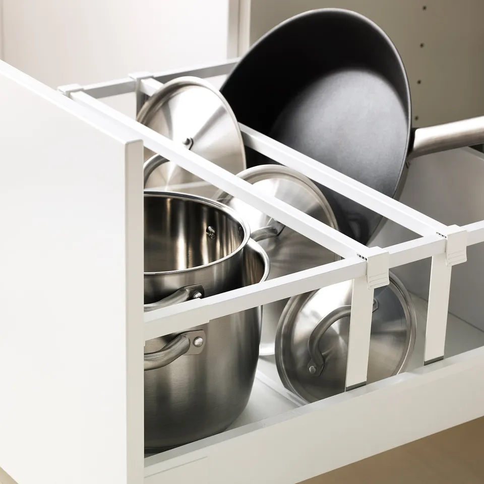 A kitchen cabinet with adjustable shelves holding pots and pans, featuring slow-close drawers.