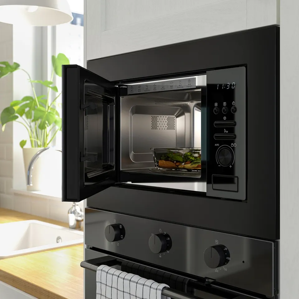 Black microwave with digital display and control knobs, open door showing turntable and pre-set options.