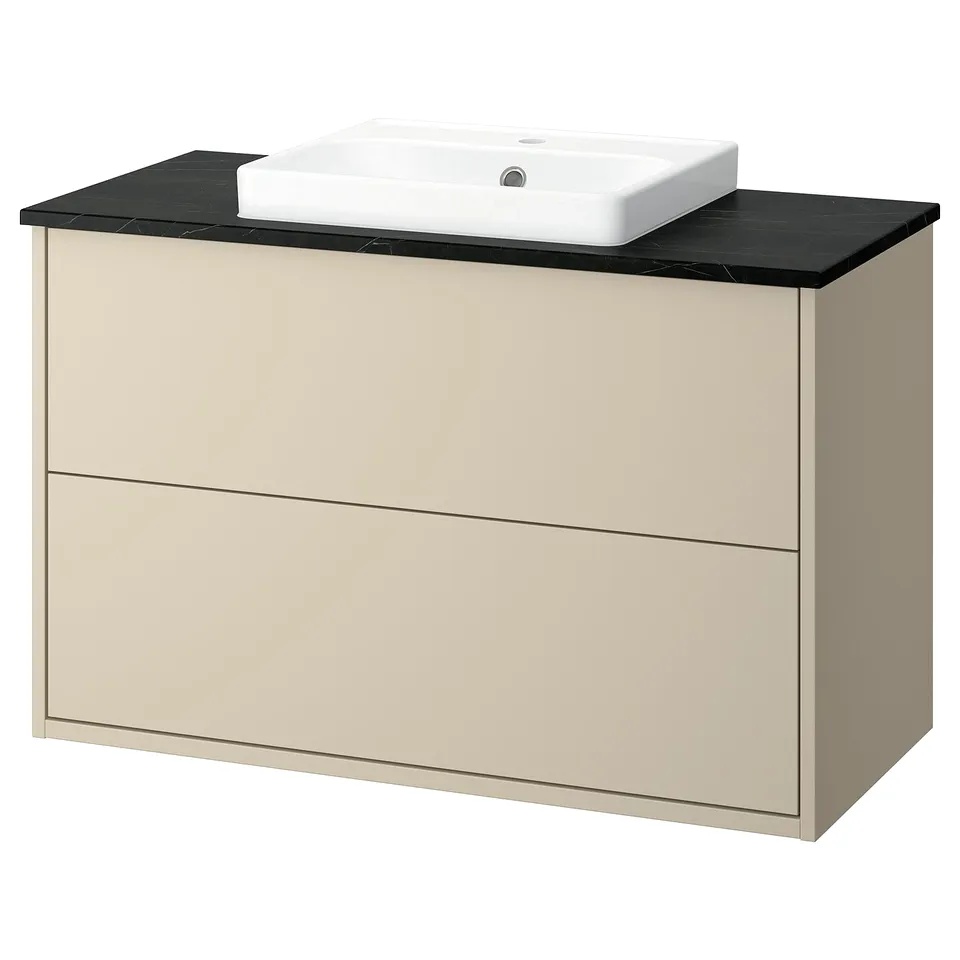 A beige HAVBÄCK bathroom vanity with a black countertop and a white basin. It has a modern, minimalist design with two drawers.