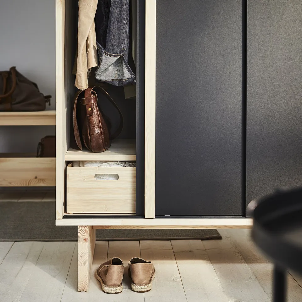 A beige GLAMBERGET wardrobe with open doors revealing storage for clothes and accessories.