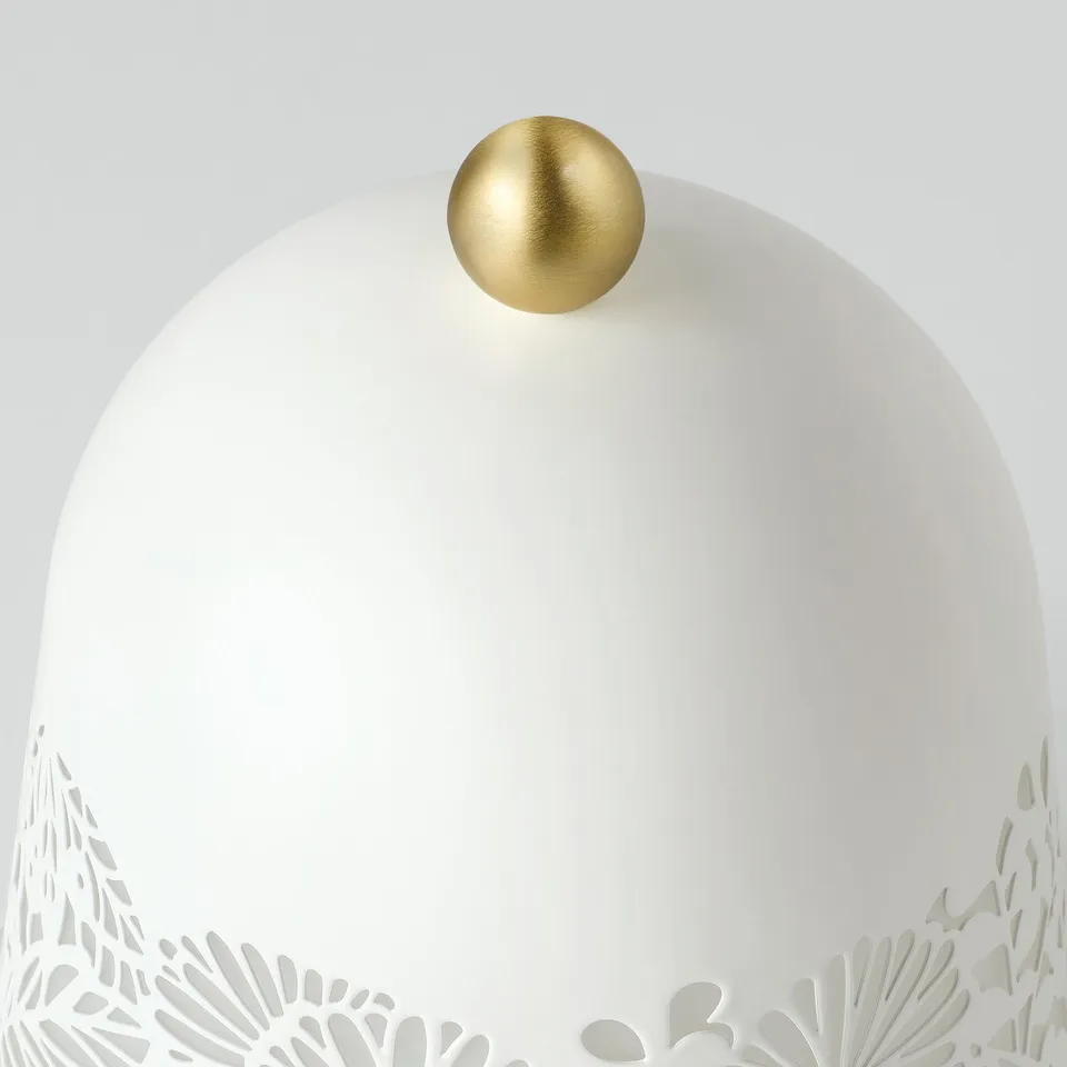 Stylish lamp with intricate leafy design and golden top, exuding quality and elegance.