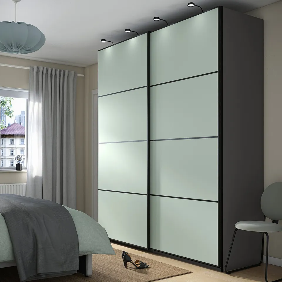 Modern bedroom with green PAX wardrobe in corner.
