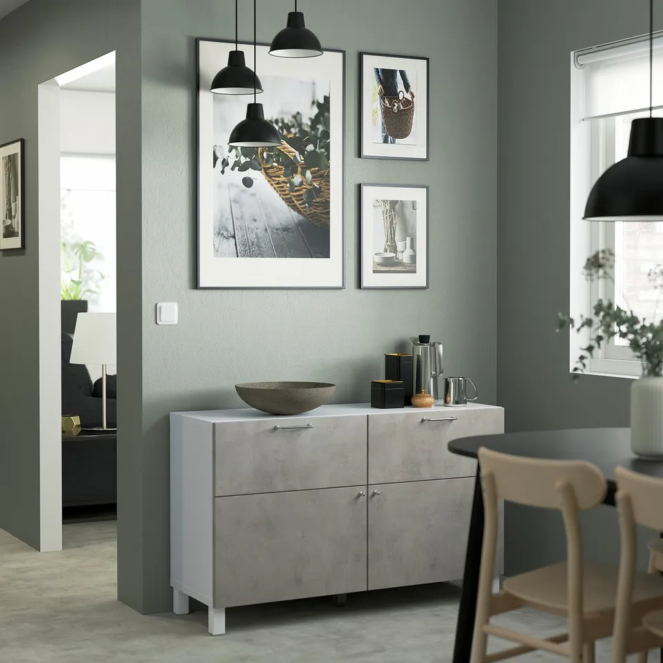 Modern living room with light wood cabinet, art wall, chairs, doorway.