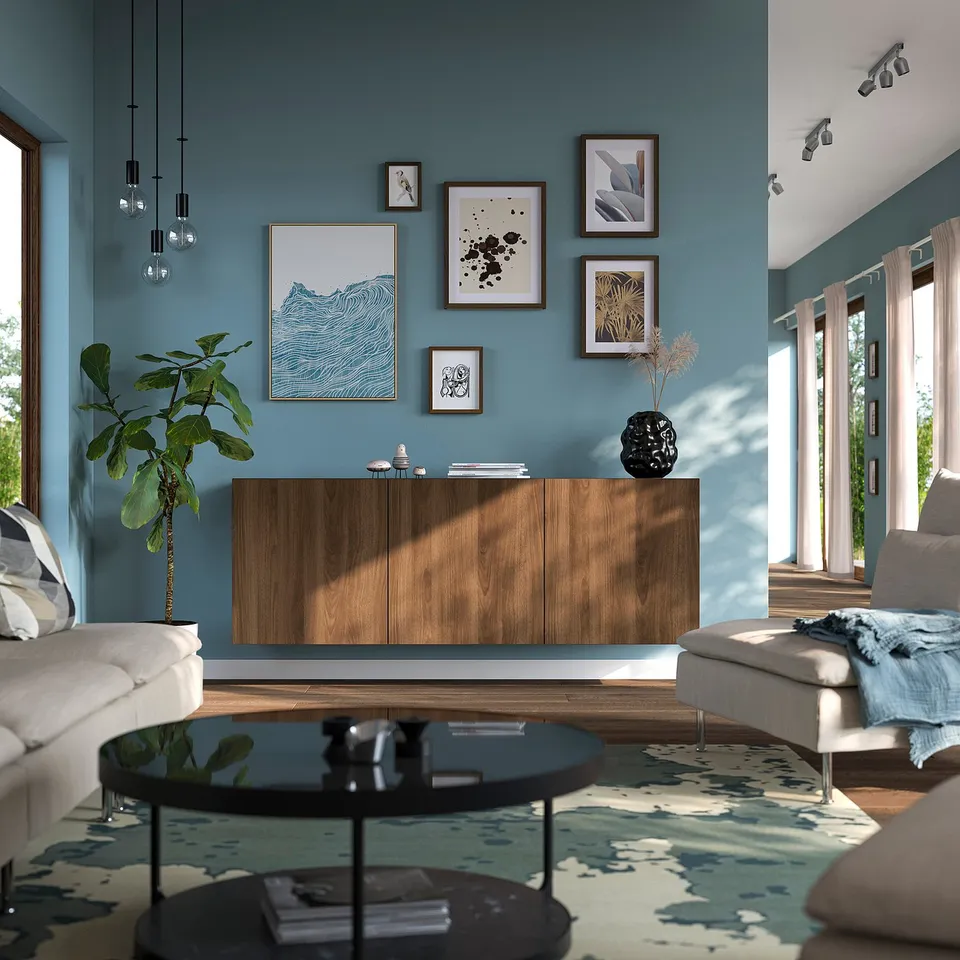 Modern living room with BESTÅ sideboard, art gallery, and glass table between white sofas.