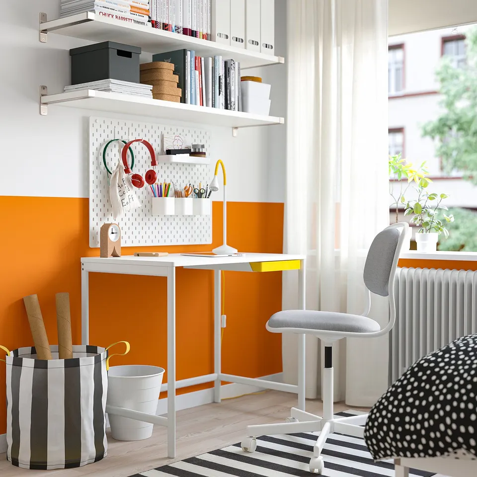 HELMER desk organiser with supplies, chair, and rug under desk on striped floor.
