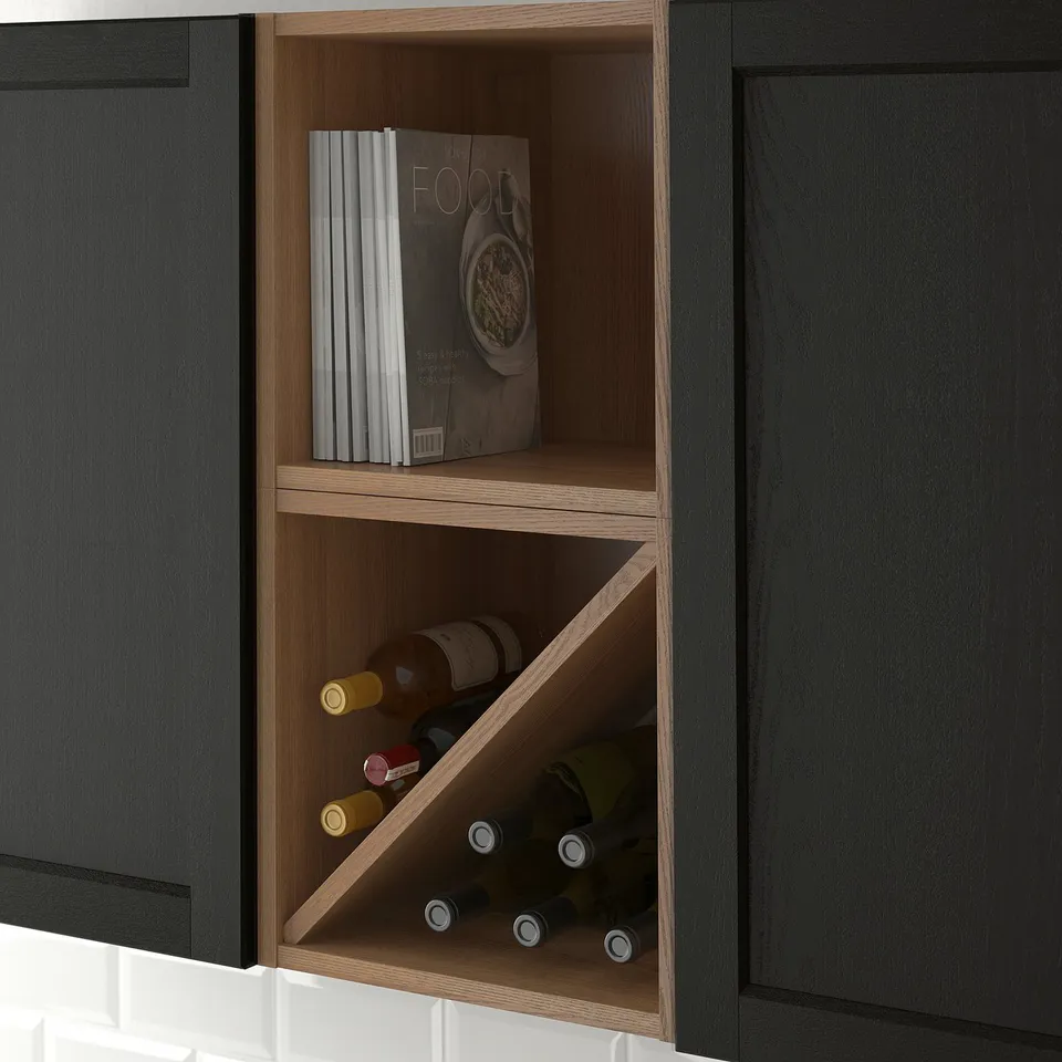 Built-in kitchen wine shelf, holding multiple bottles and cookbooks, nestled between dark cabinets.