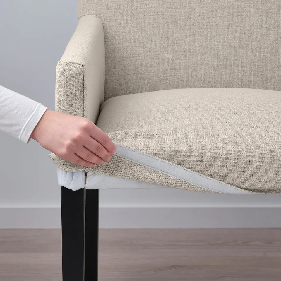 Person securing chair cover with hook-and-loop fastener.