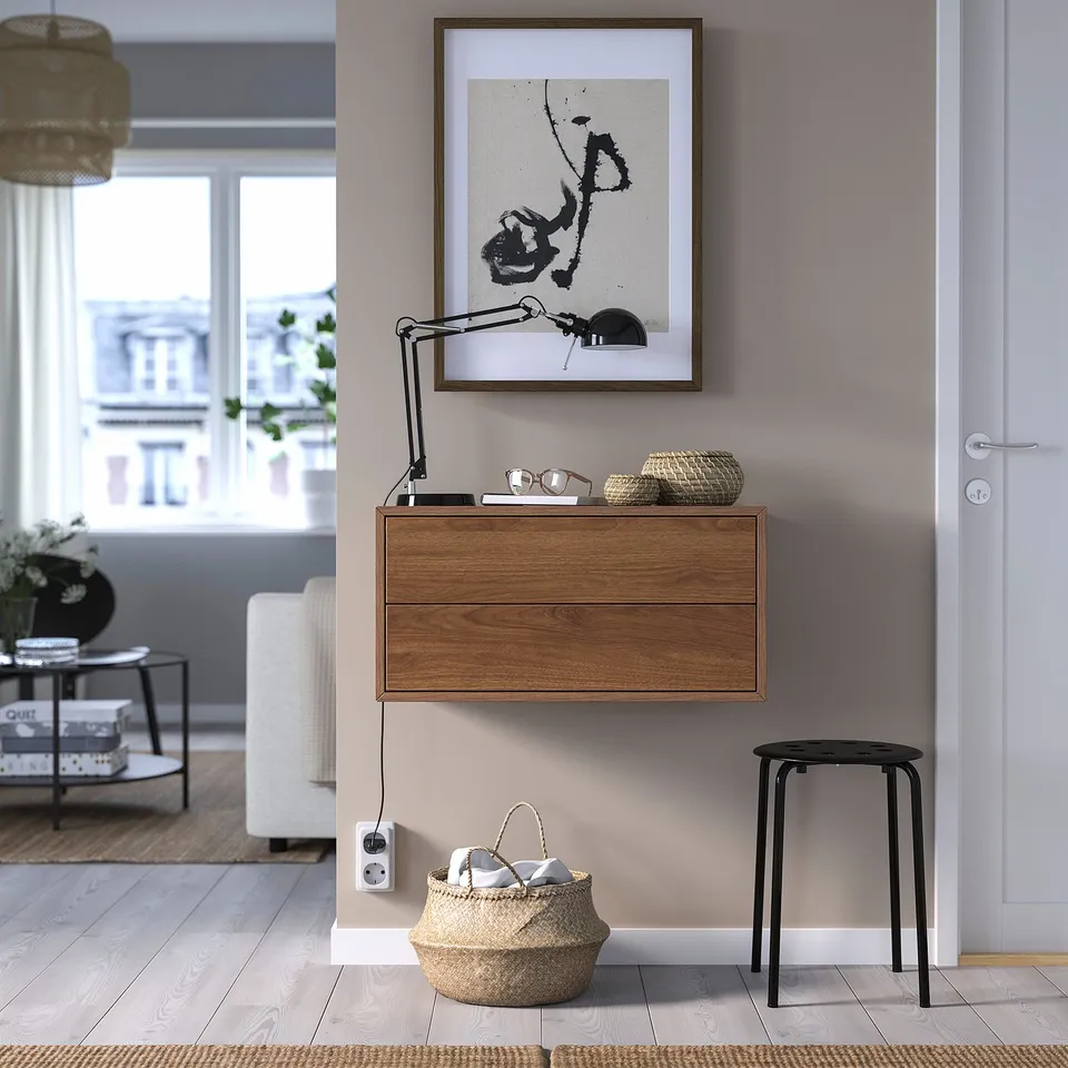Modern living area with EKET cabinet, art, lamp, and basket.