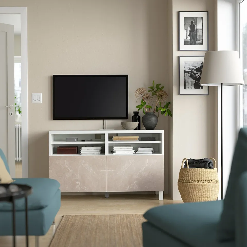 Modern living room with BESTÅ tv bench, flat-screen, books, blue couch, decor.