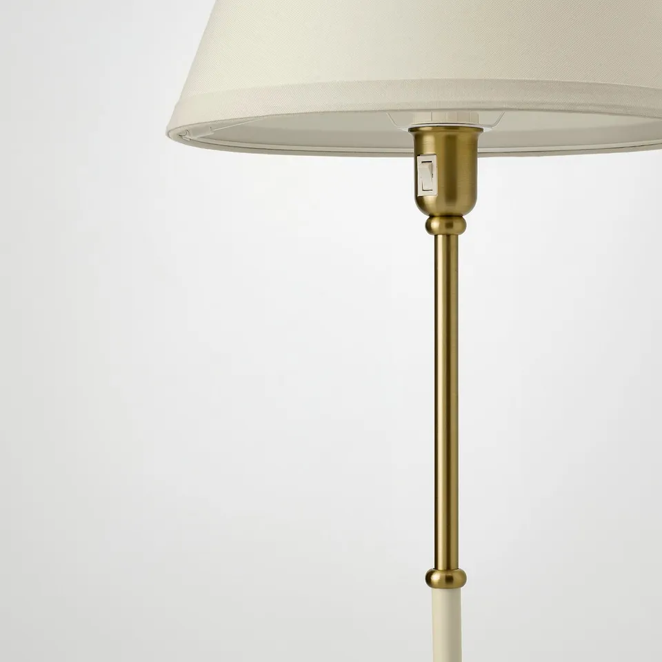 A stylish lamp with a beige shade and gold stand, reflecting quality craftsmanship and elegant design.