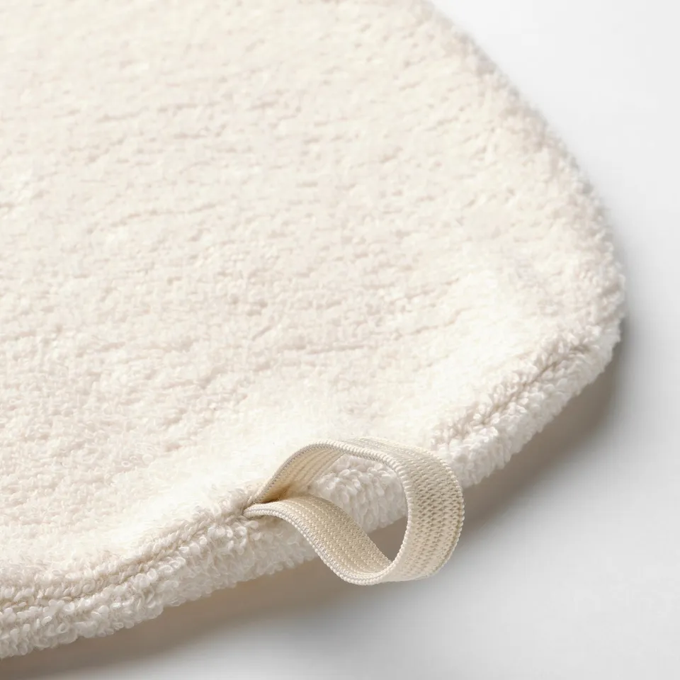 Cream-colored towel with soft, thick texture and elastic loop for secure fastening.