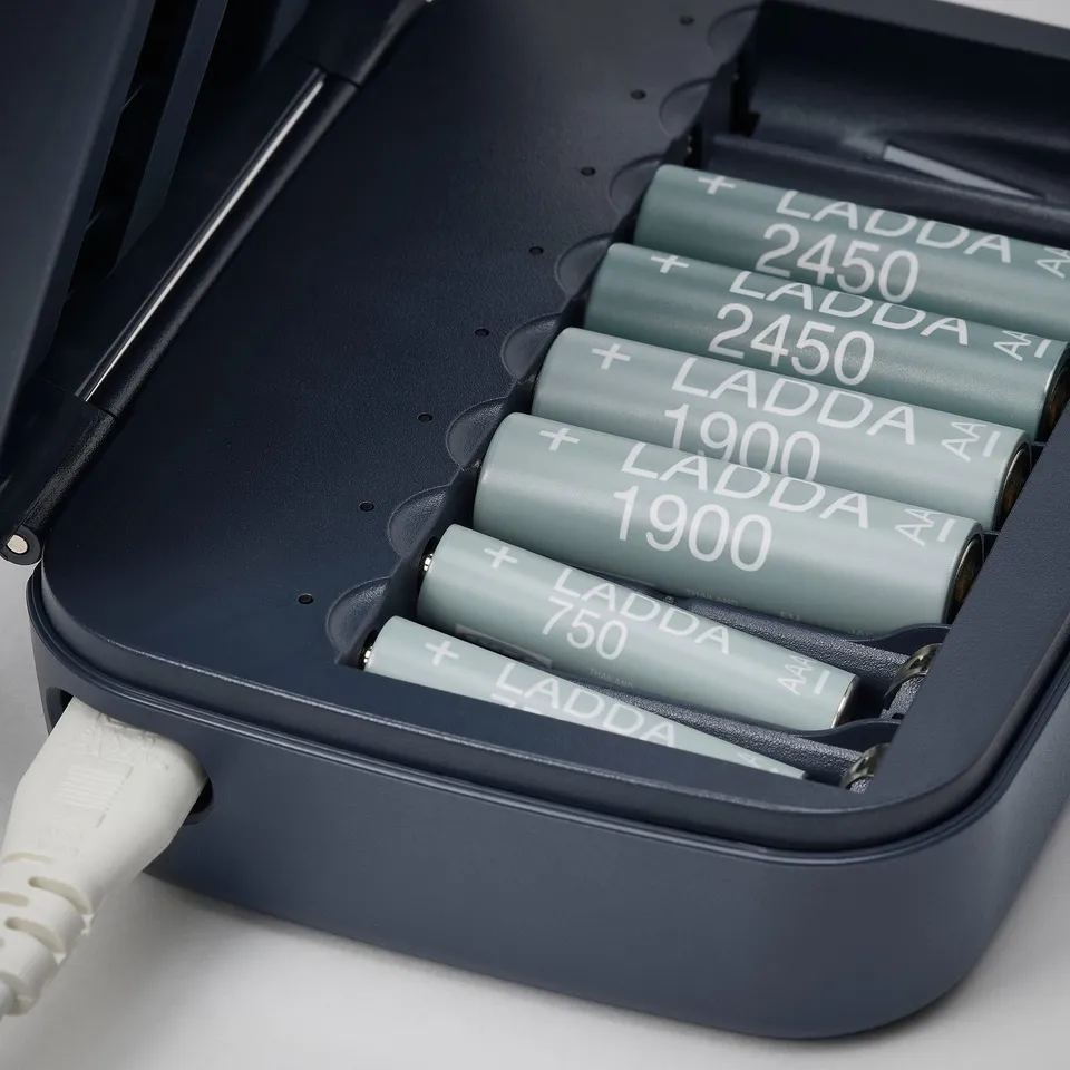 Dark grey LITOSFÄR battery charger holding eight ladda rechargeable batteries, four 2450 mah and four 1900/750 mah, with a white charging cable.