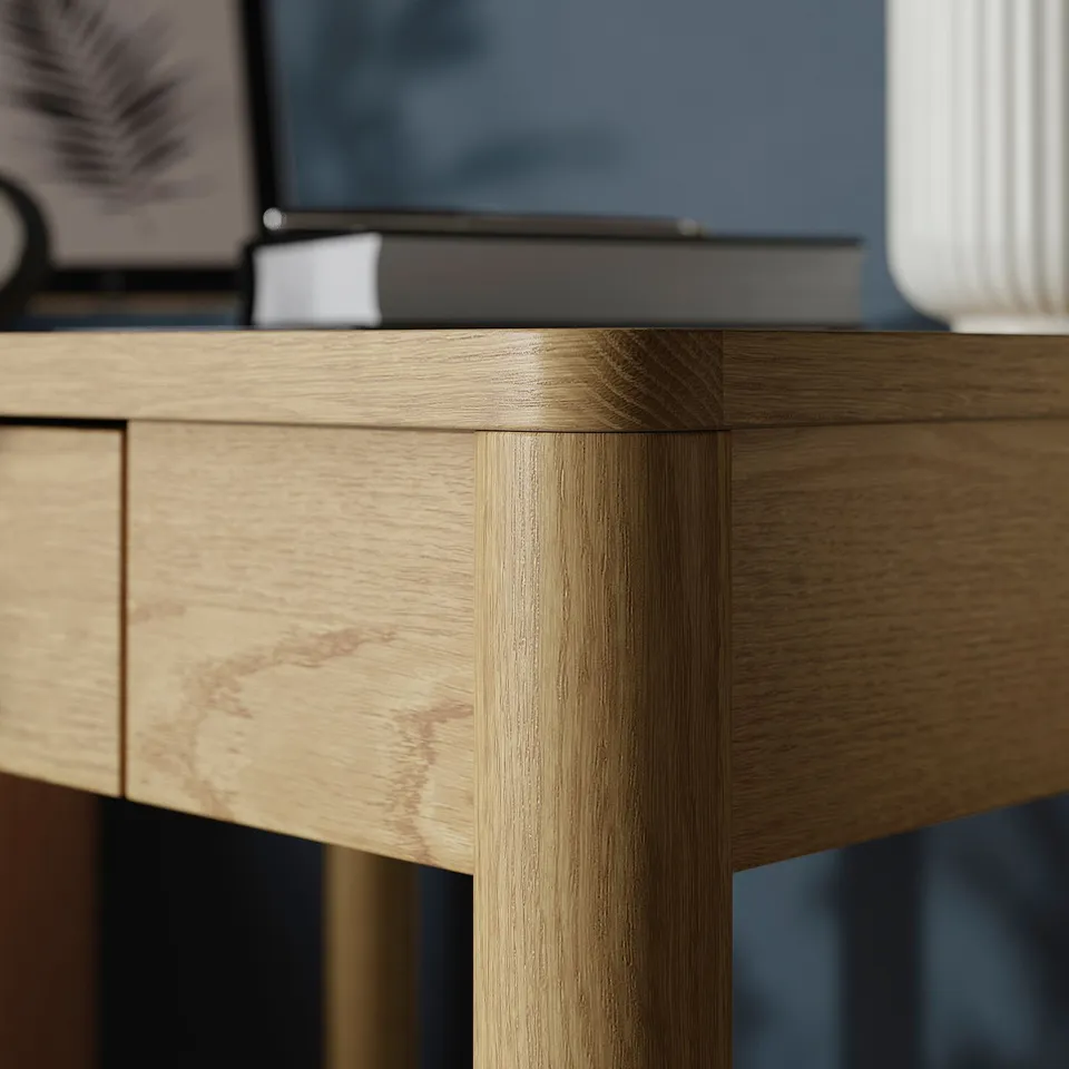 Close-up of TONSTAD desks corner, showcasing smooth, brushed oak veneers quality and craftsmanship.