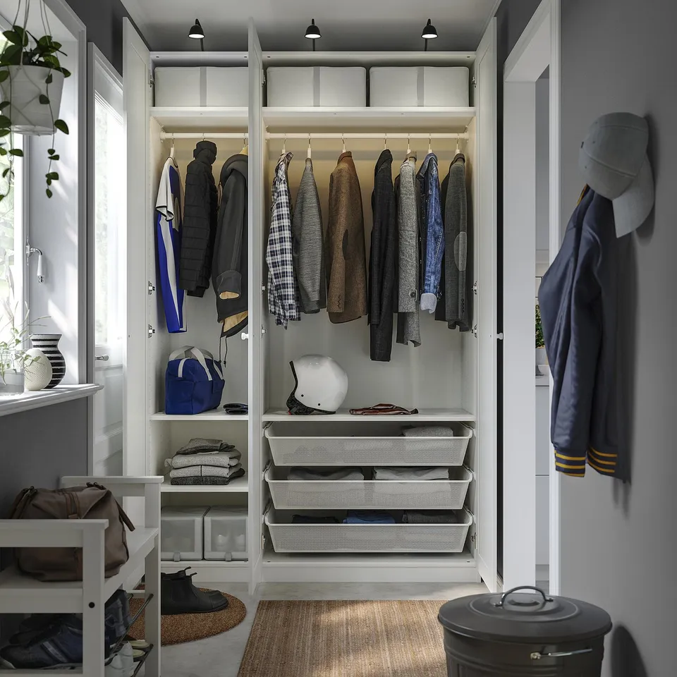 A well-organized closet with hanging jackets, folded clothes, and shelves. White PAX system with integrated lighting.