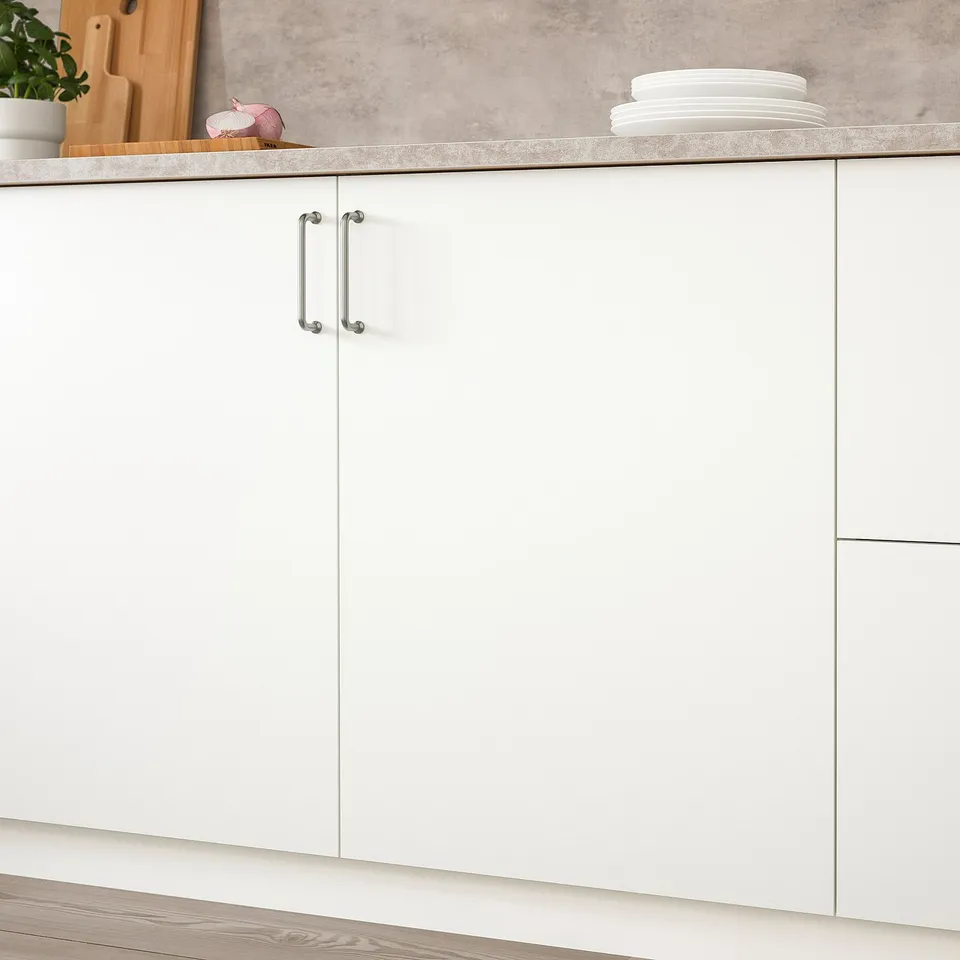 White kitchen cabinet with smooth surface and a metal handle, featuring open compartments above.