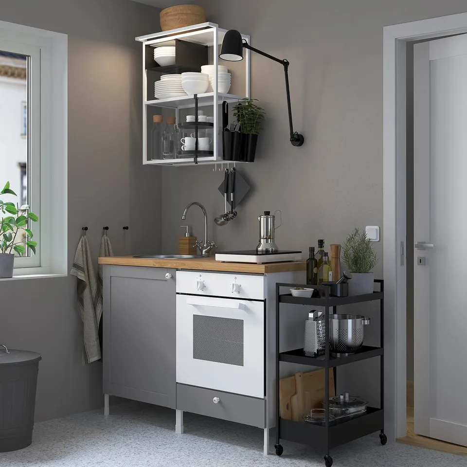 Modern kitchen with led lights, oven, grey cabinets, wood counter, plants, hanging towels.