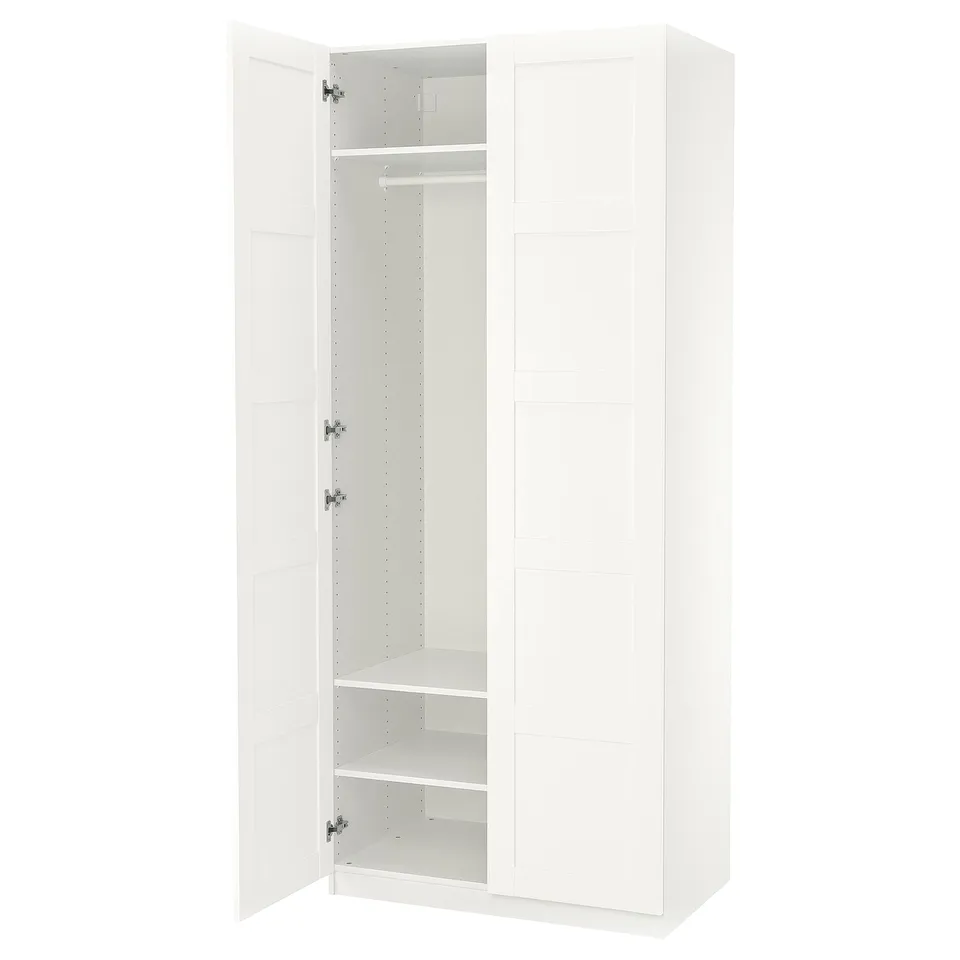 White PAX wardrobe with one door open, revealing hanging rod and shelves inside. Simple design with clean lines.