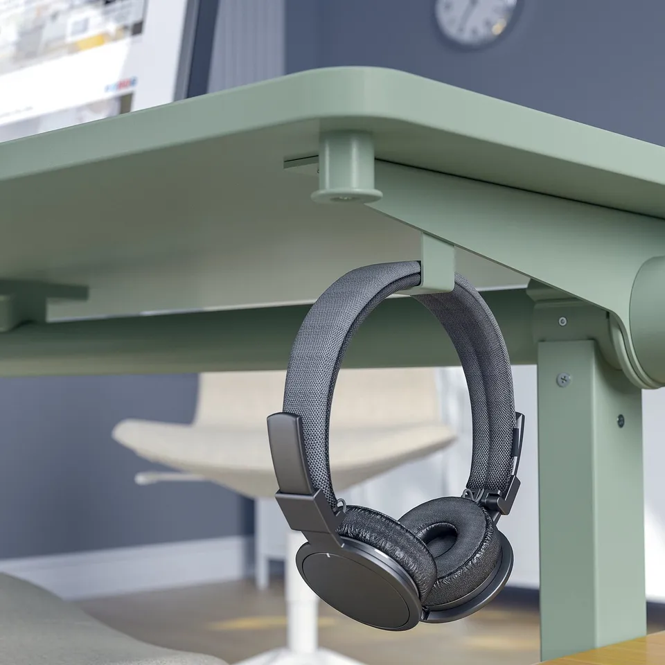 Headphones hang on table hook, ready for use.