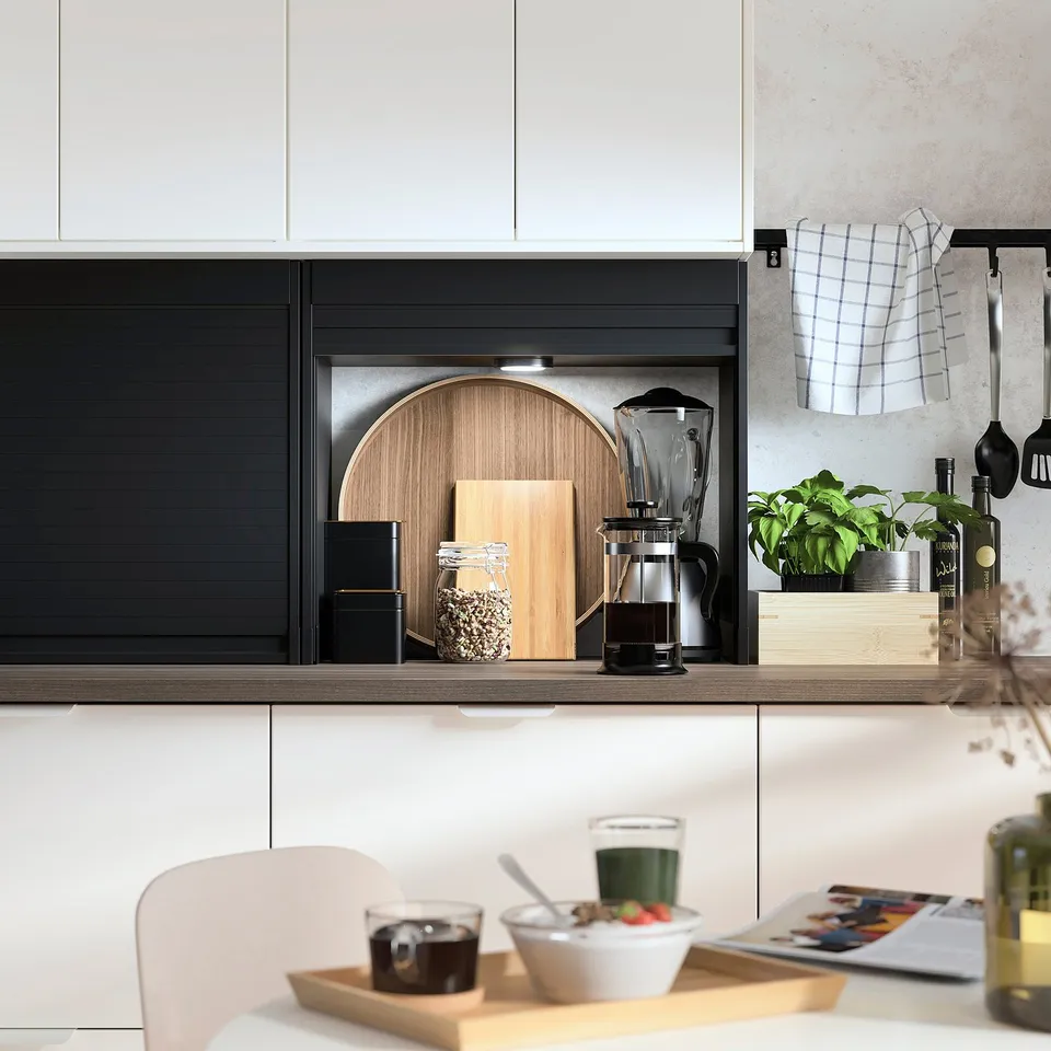 Modern kitchen with TITTEBO black appliance garage, wood cutting board, blender, jars, plants, and breakfast on a wooden tray.