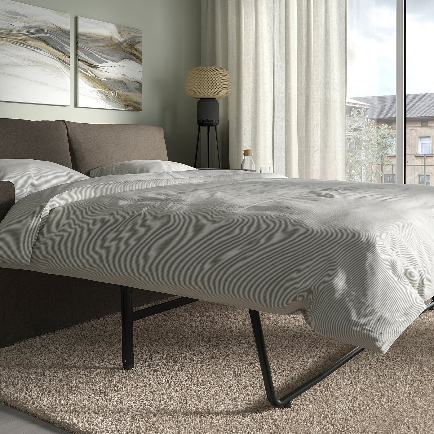 Modern sofa-bed, grey with black legs, near window, converts to bed.