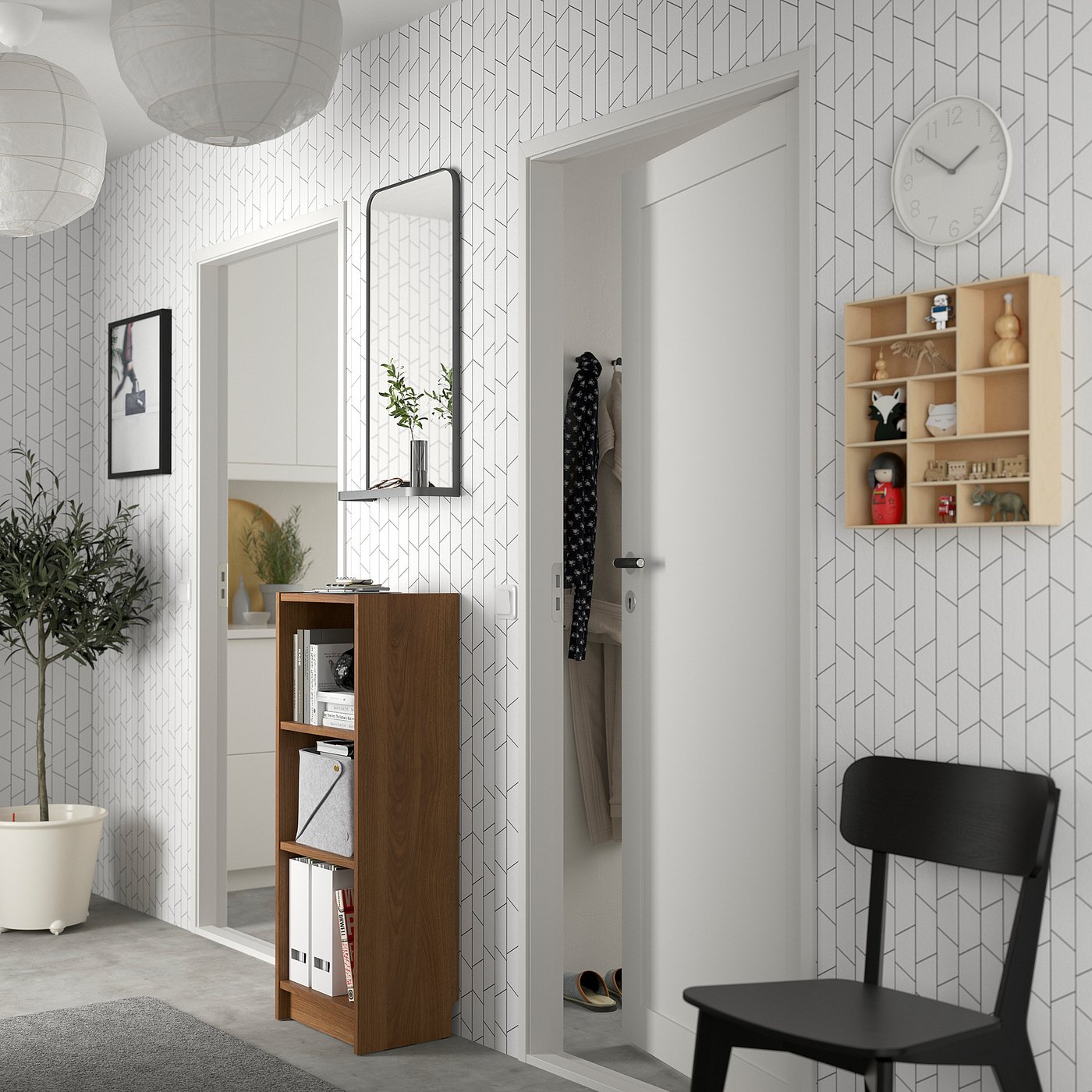 BILLY bookcase in geometric room, with mirror, clock, chair, & decor.