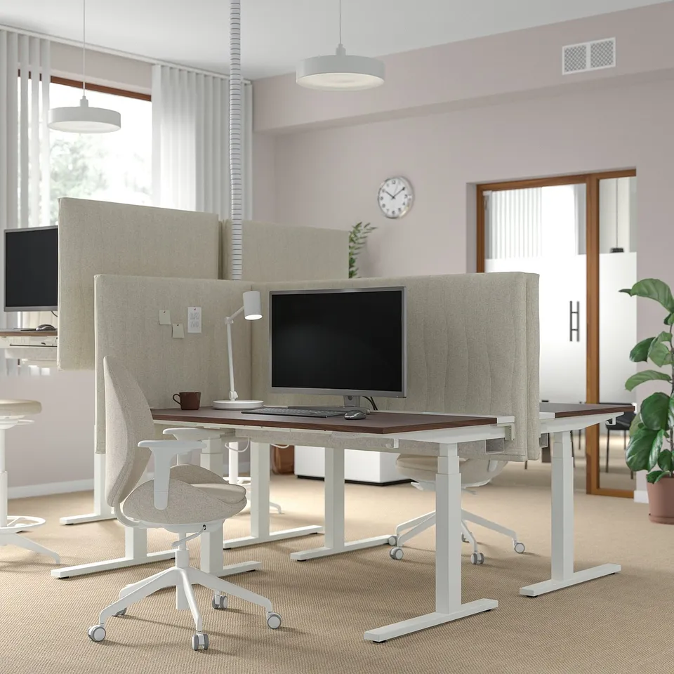 Modern office: MITTZON desk with beige acoustic screen. Computer, chair, and plants.