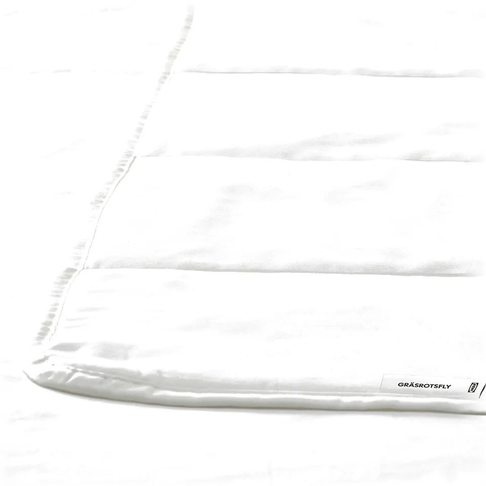 Close-up of white, high-quality duvet with smooth fabric.