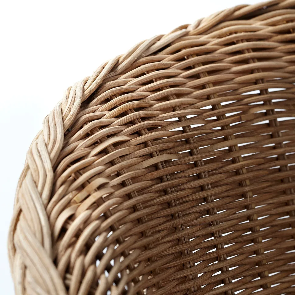 Close-up of intricately woven natural rattan basket, showcasing fine craftsmanship and texture.