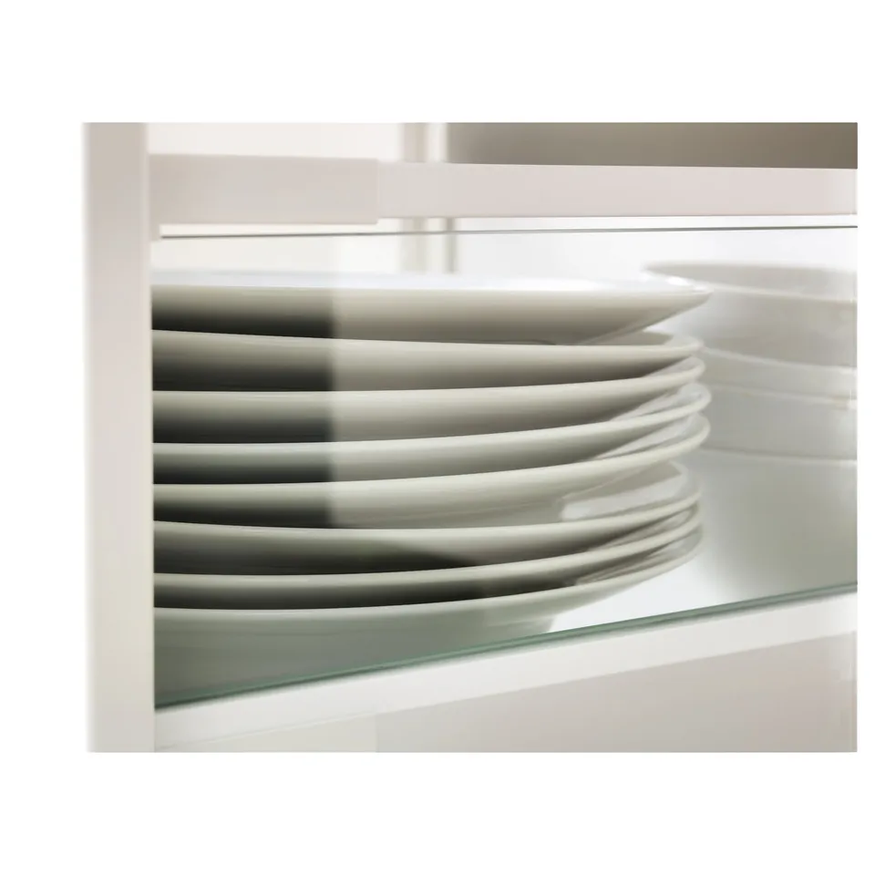 Stacked white plates in a glass-sided drawer.