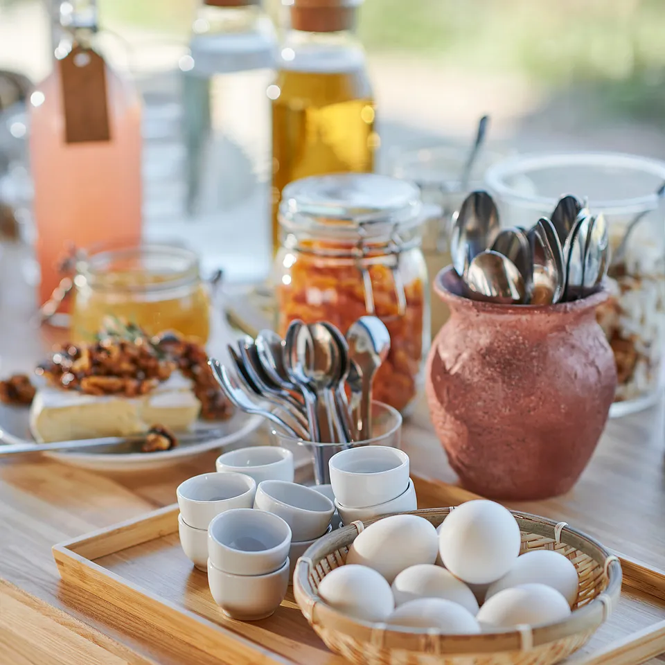 Breakfast tray with bamboo veneer, white ceramics, glass jars, and rustic utensil holder.