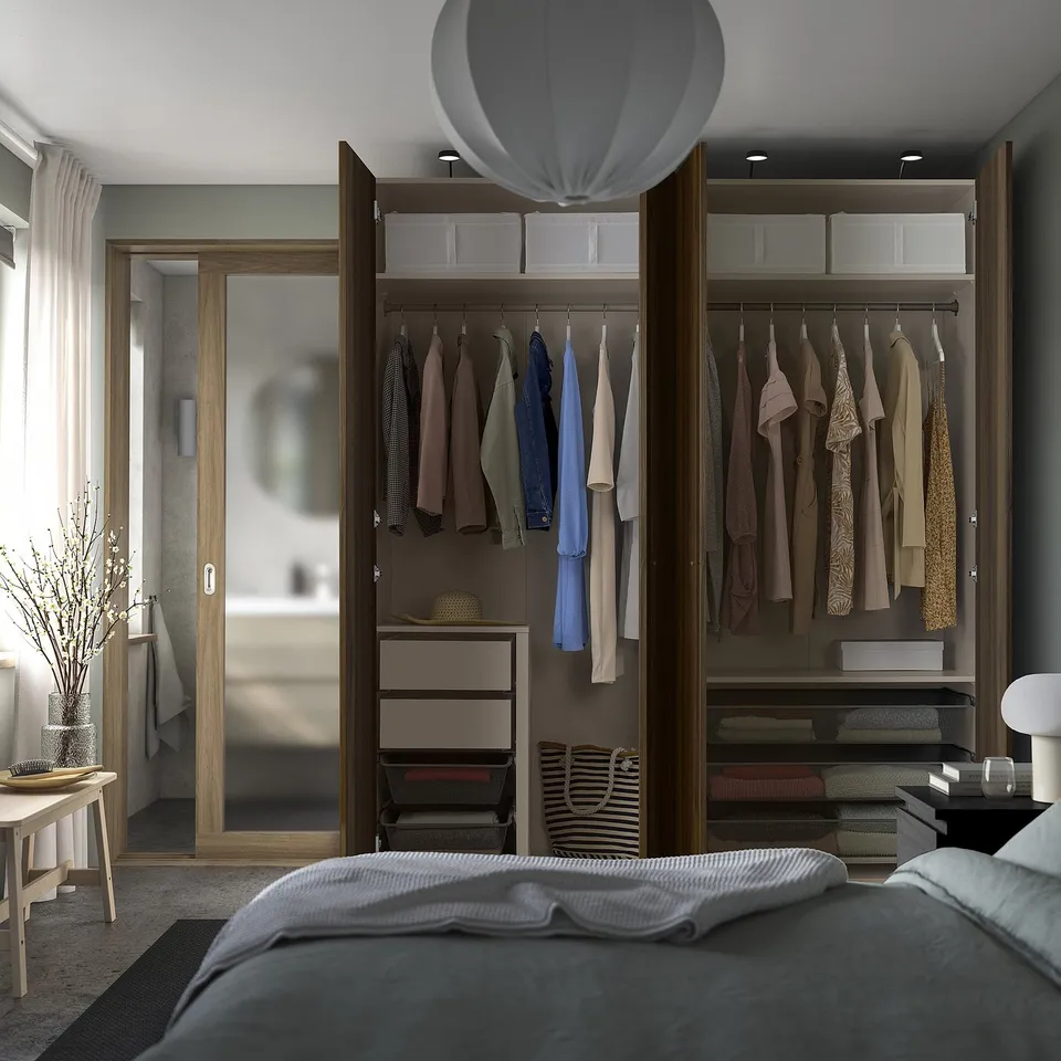 Bedroom with open wardrobe showing clothes, drawers, and accessories. Soft-closing hinges and adjustable feet visible.
