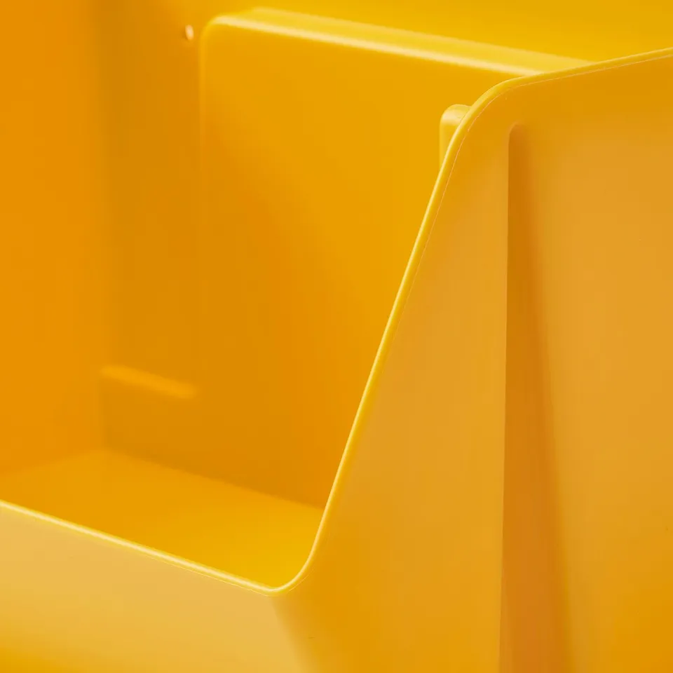 Bright yellow plastic storage organiser with smooth, curved edges and a divided compartment, showcasing its quality and design.