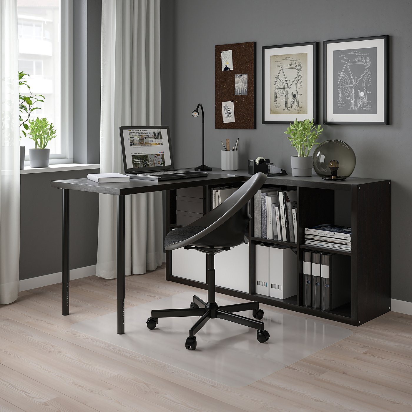 Modern black home office setup with KALLAX shelving, wooden floor, grey walls, large window, desk with laptop, black chair, and decorations.
