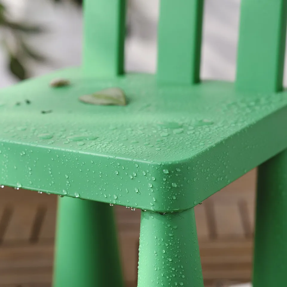 Bright green childrens table with water droplets, perfect for outdoor play.