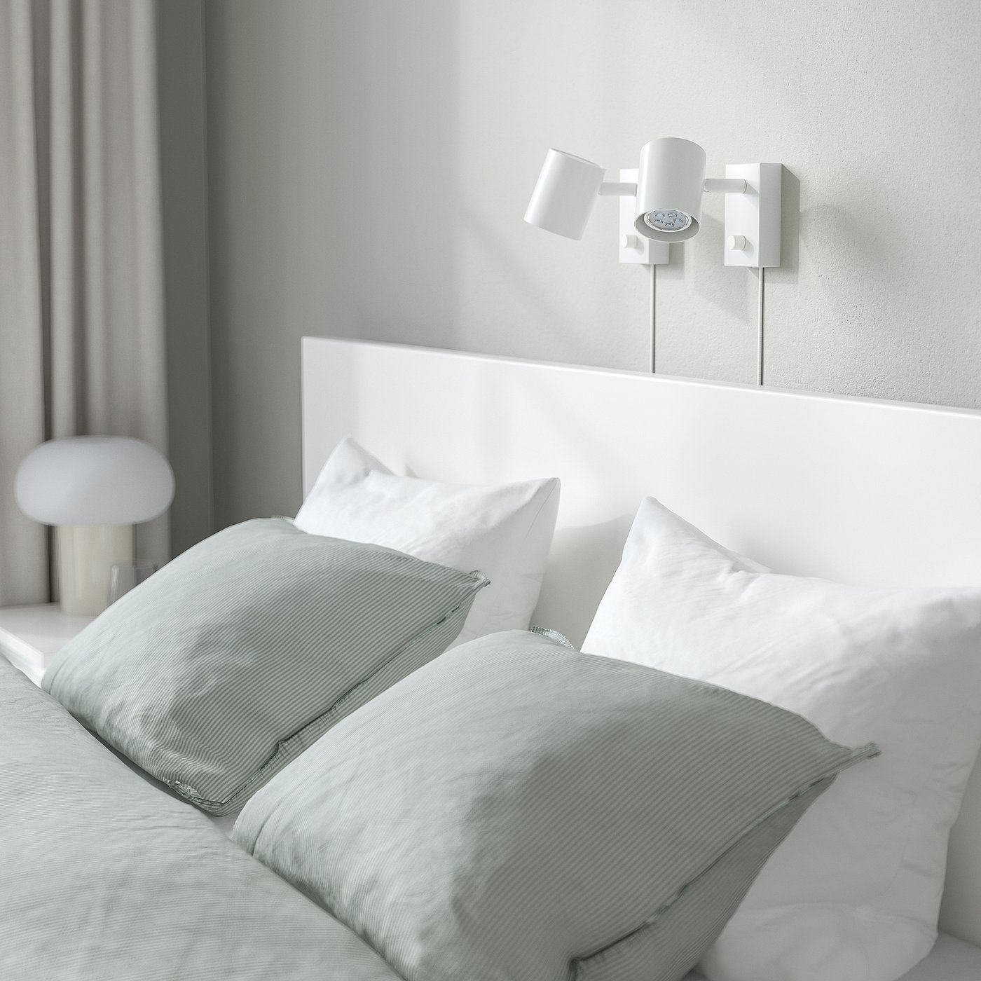Modern bed with high white headboard, light green bedding, wall lights, sleek style.