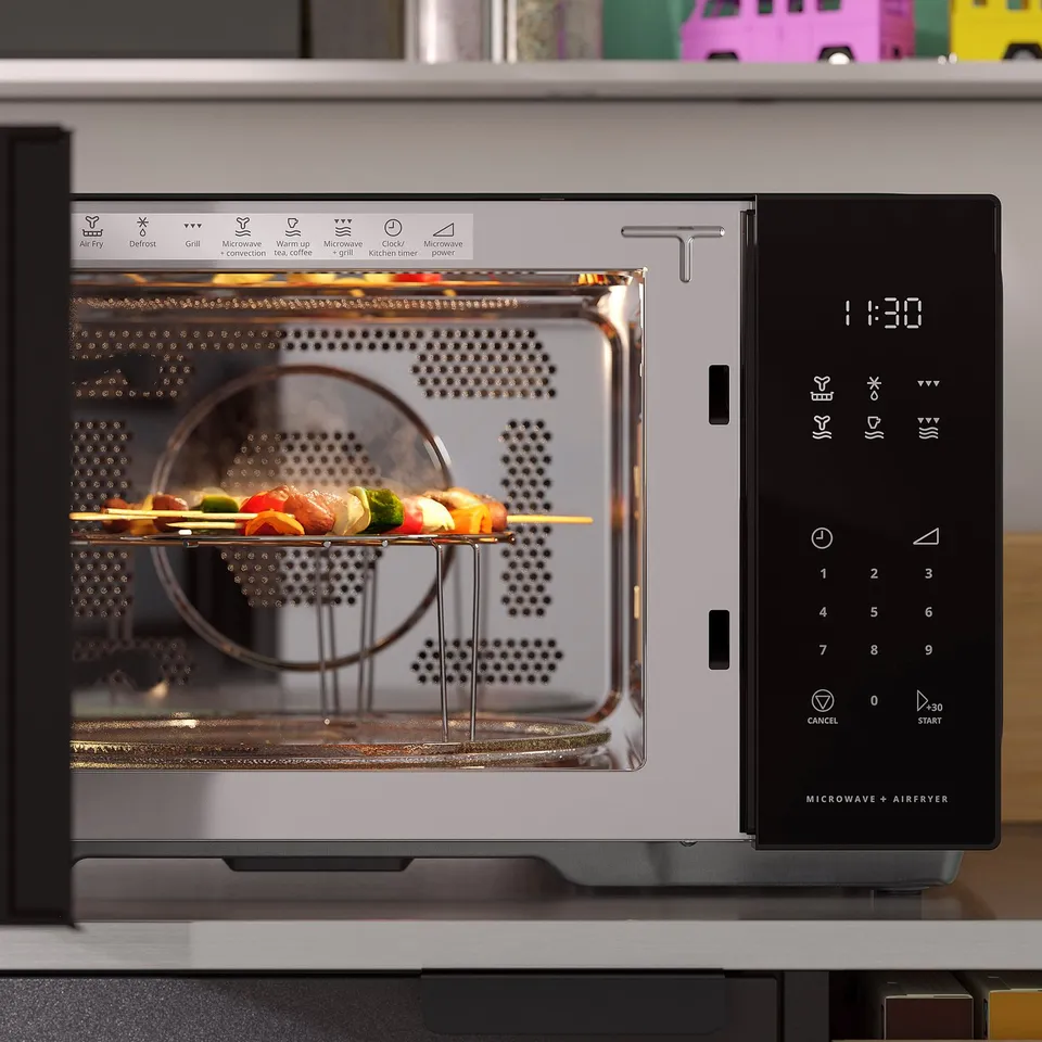 Microwave with air fryer cooks veggie skewers. Digital display shows time and mode. Control panel offers various settings.