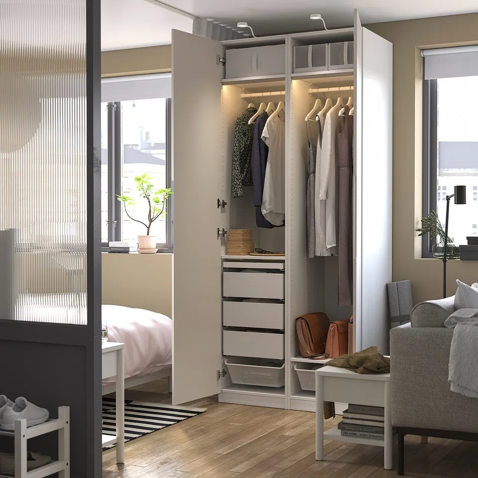 Wardrobe with integrated lights and hanging storage. Soft-closing hinges and adjustable feet for stability. Clothes and accessories organised neatly.