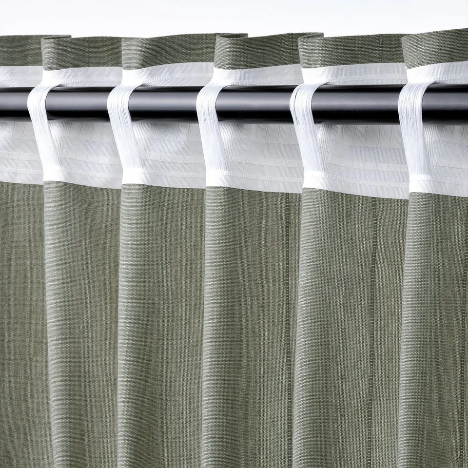 Close-up of LENDA curtains in grey-green with header tape and tie-backs, hanging on rod.