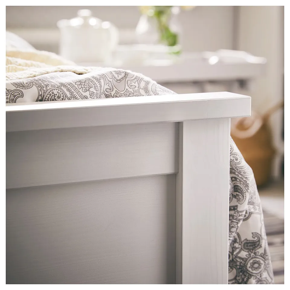 White wooden bed, traditional design, with ornate bedding, showcasing natural solid pine finish.