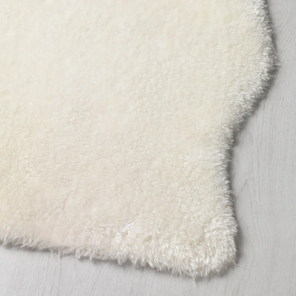 Plush white rug on wood floor.