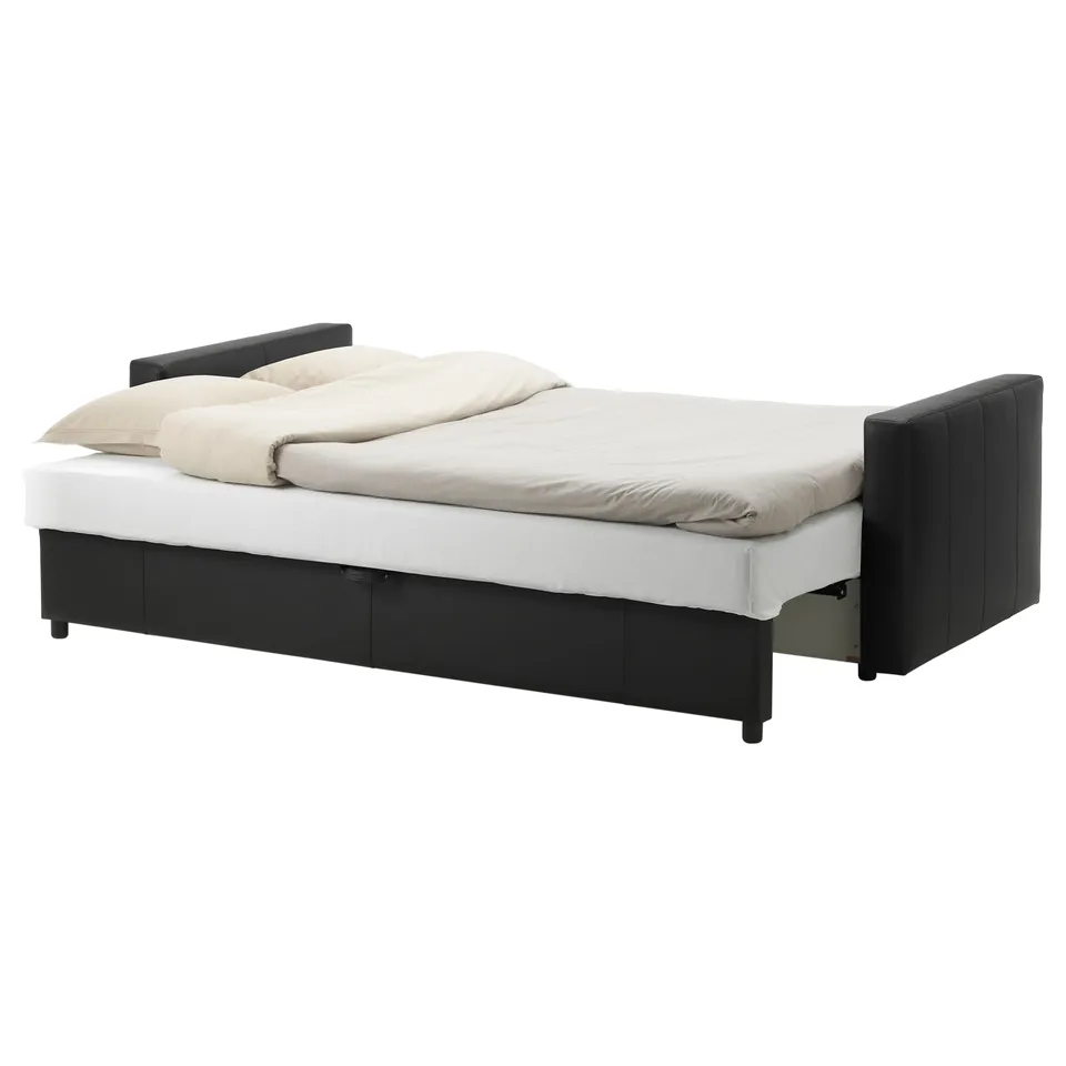 Black convertible sofa bed with white mattress and folded beige blanket, featuring built-in storage.