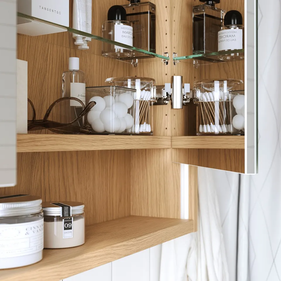 Wooden mirror cabinet with built-in lighting, holding bottles, cotton swabs, and jars. Integrated shelves and safety glass.