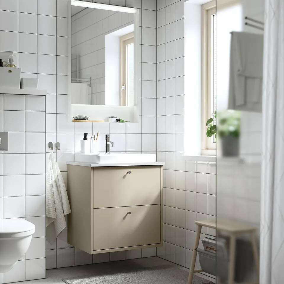 Modern bathroom with beige HAVBÄCK vanity, white-tiled walls, and minimalist decor.