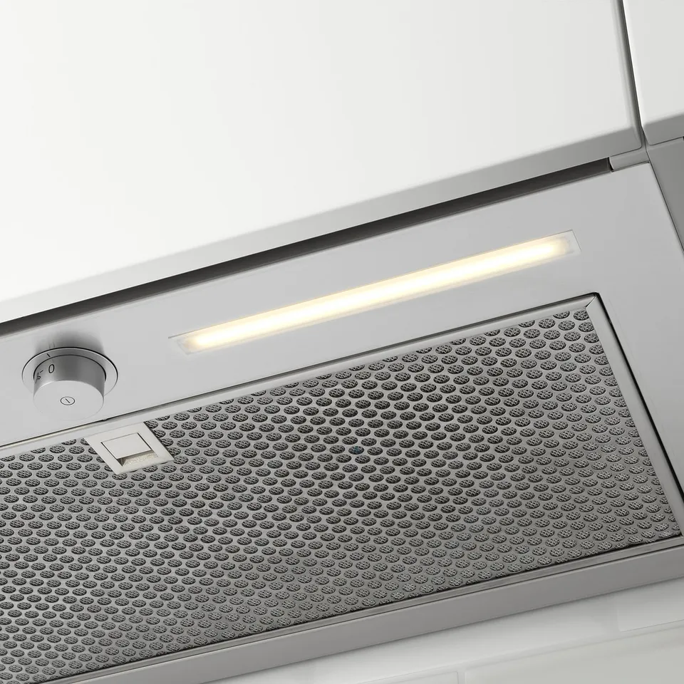 Stainless steel kitchen hood with led light, integrated into cabinet.