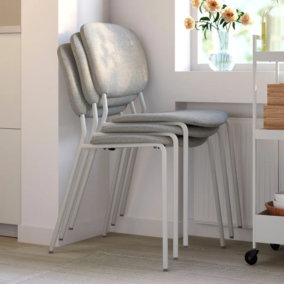 Stackable dining chairs with cushioned seats and backs for comfort and easy storage; modern, minimalist design ideal for indoor use.