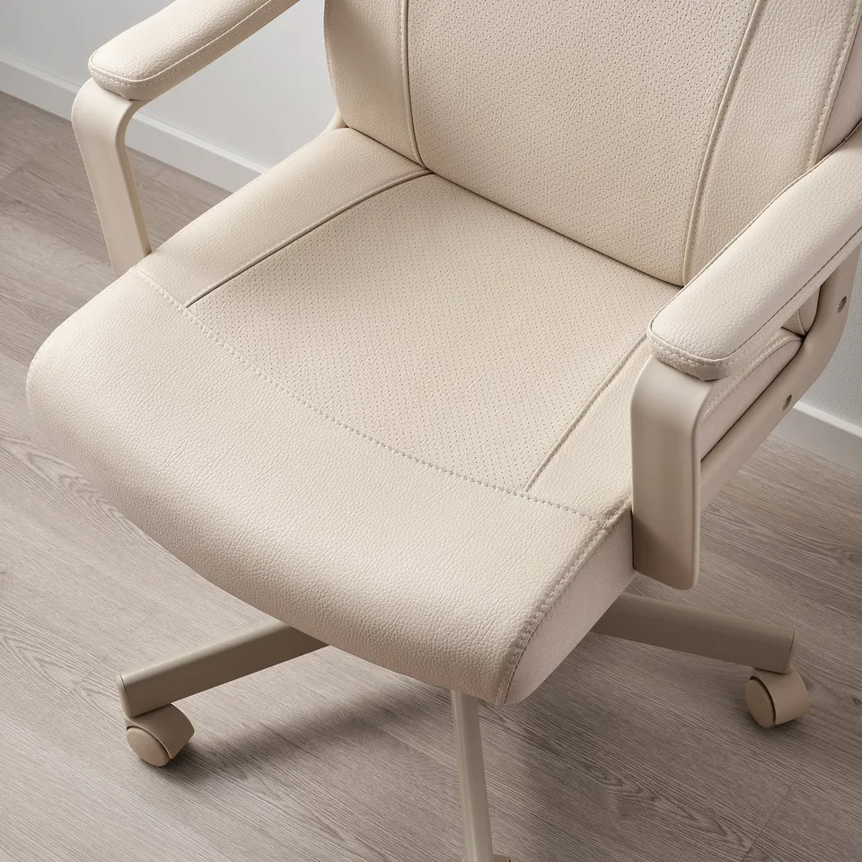 Modern office chair with beige fabric, padded armrests, and wheels on wooden floor.
